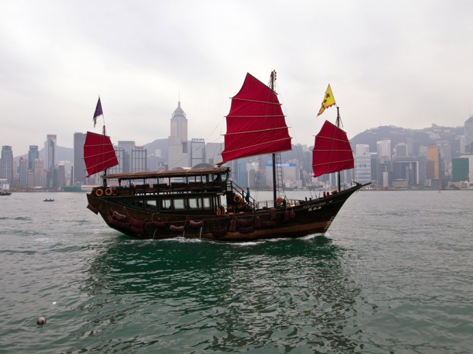 Eine traditionelle Dschunke vor der Skyline von Hong Kong Island
