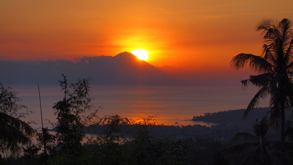 Sunset with view at Senggigi Beach and the Mount Agung on Bali