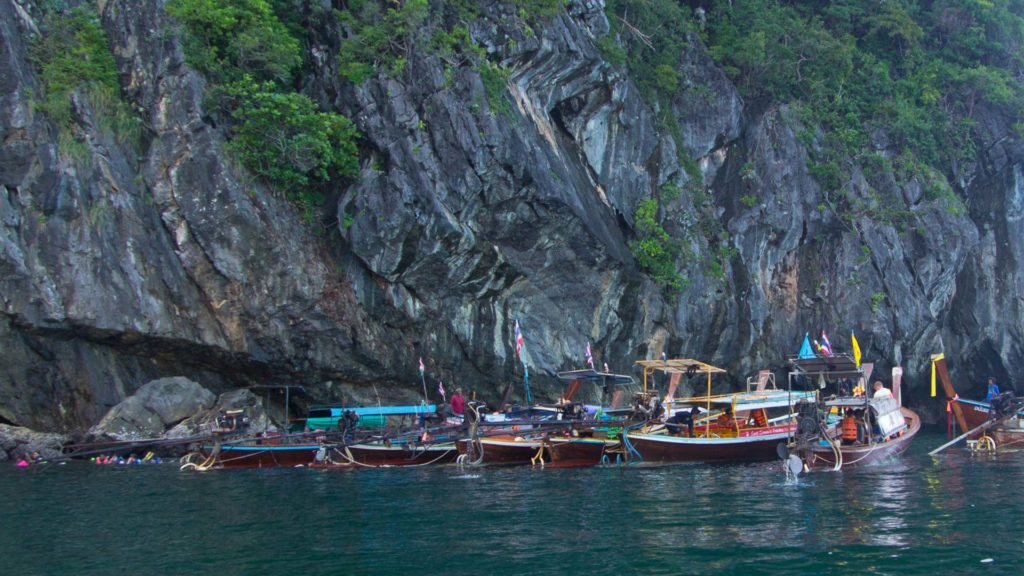 Many boats in front of the entrance to the Emerald Cave on Koh Mook