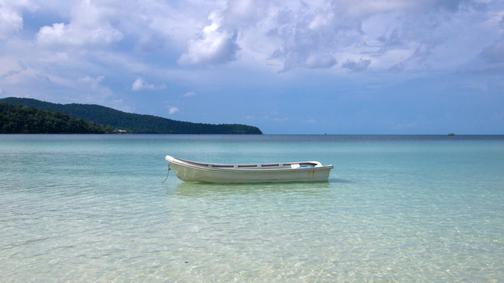 A lonely boat in the crystal clear water of the Saracen Bay, Koh Rong Samloem