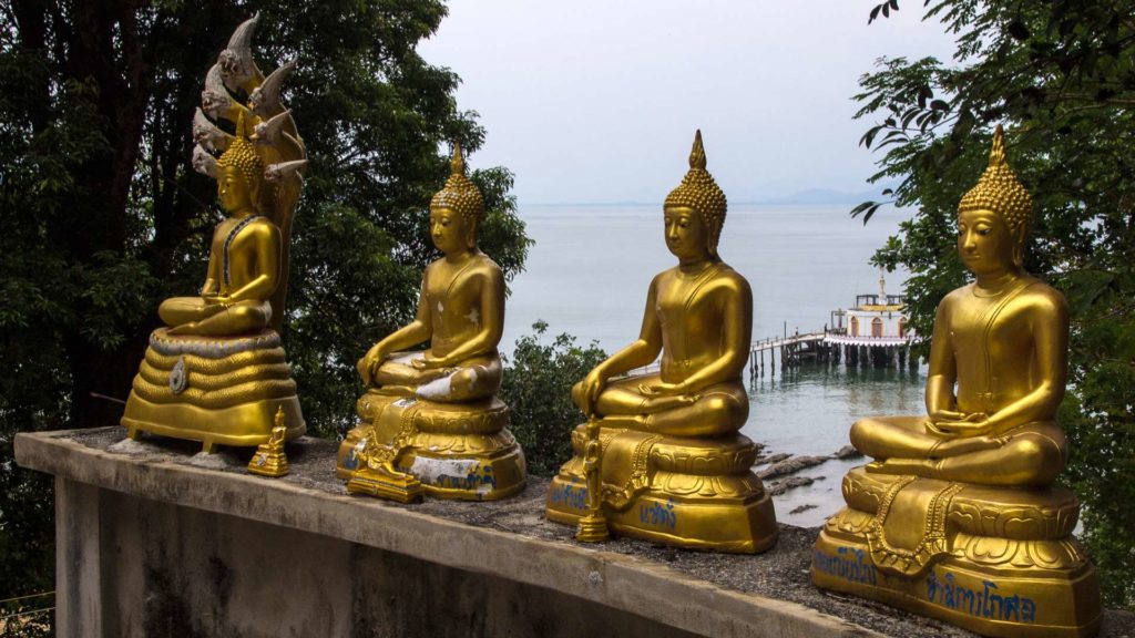 Goldene Buddha-Statuen und Aussicht vom Big Buddha auf das Tempelpier von Koh Phayam