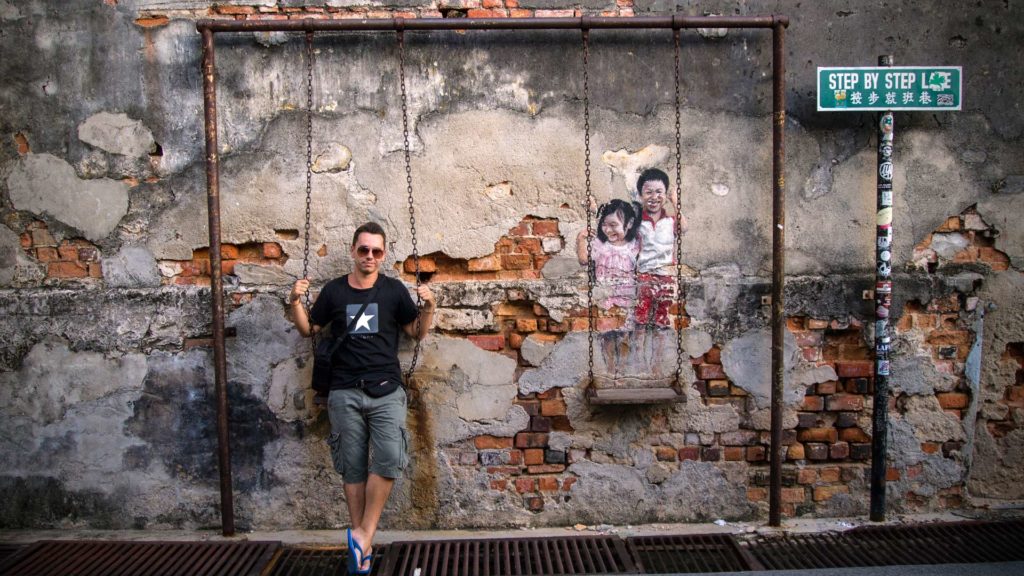 Marcel mit Street Art in George Town, Penang (Kinder auf Schaukel)