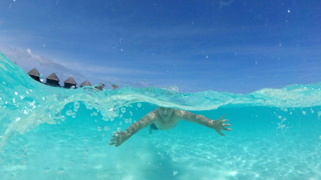 Marcel beim Schwimmen im türkisen Wasser der Malediven (aufgenommen mit der GoPro und einem Dome)
